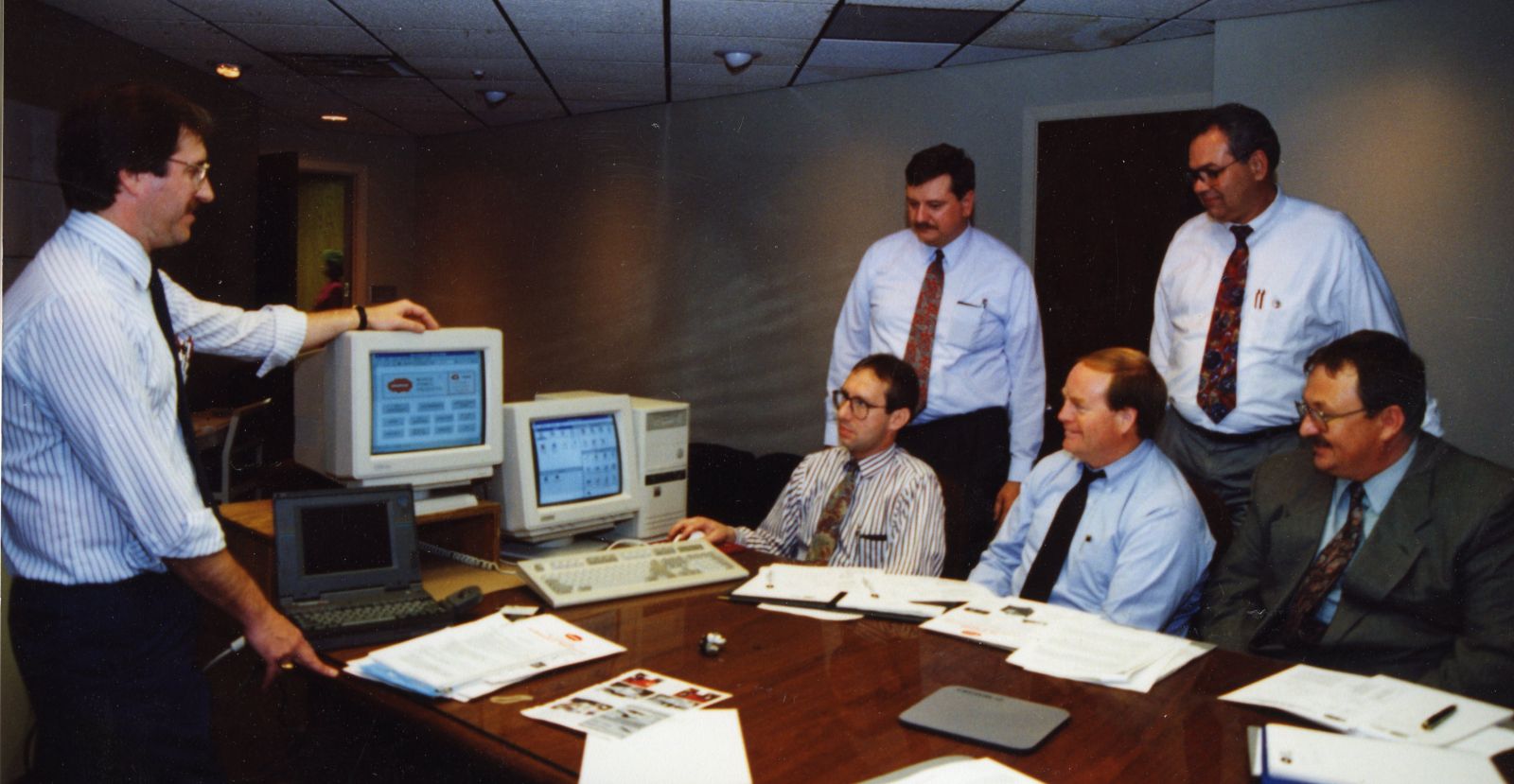 An archival photo from the sales meeting in 1994 showing six men learning about computer software.